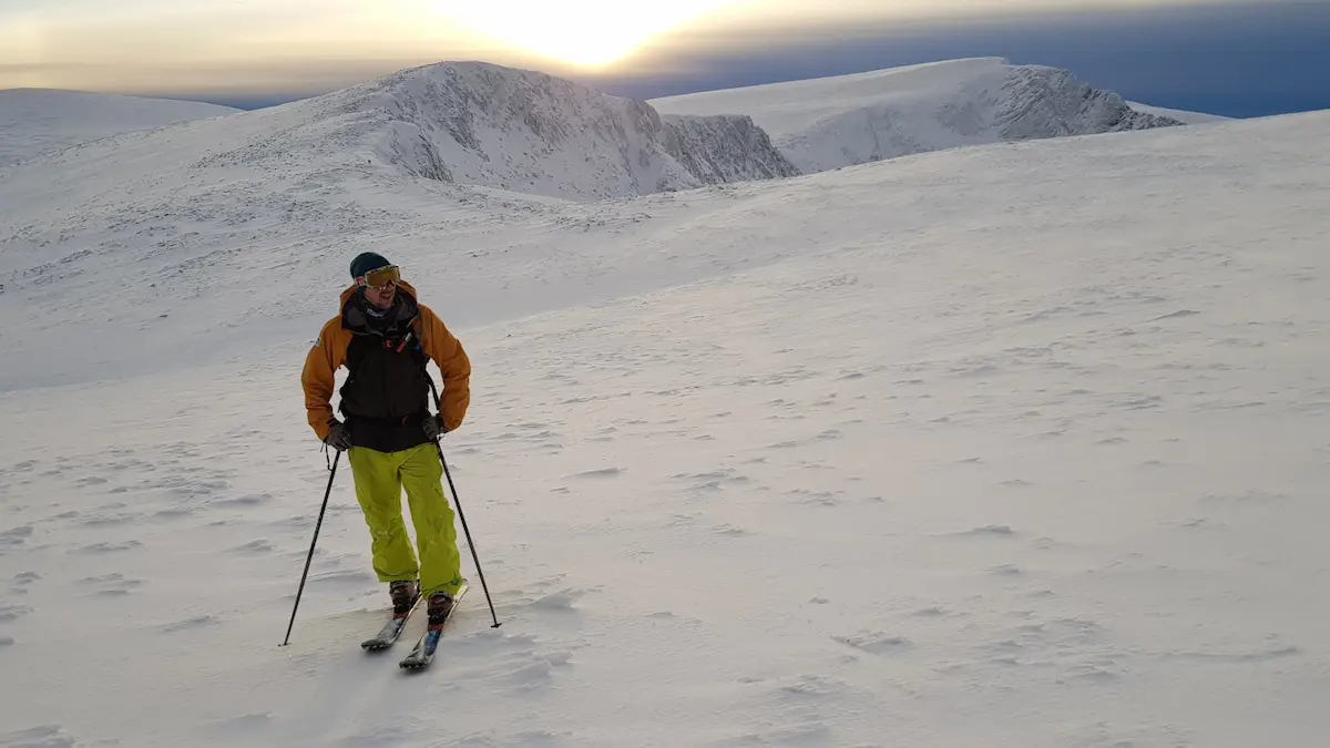Ski tourer offpiste on mountain at sunset